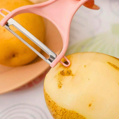 Personne qui retire une impureté à l'aide du coin prévu à cet effet d'un économe rose. Elle tient une pomme de terre dans sa main gauche et un économe dans sa main droite.