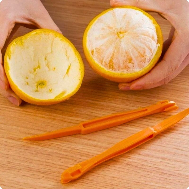 Orange avec sa peau retirée sur une moitié avec un epluche agrume posé devant