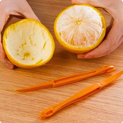 Orange avec sa peau retirée sur une moitié avec un epluche agrume posé devant