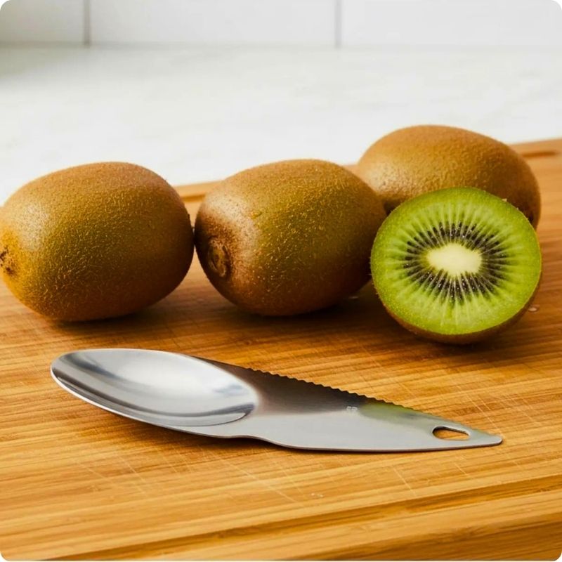 epluche kiwi confort'ine posé sur une planche à côté de kiwis