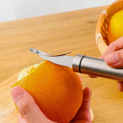 Personne en train d'éplucher une orange avec un éplucheur adapté, en utilisant l'arrière de l'éplucheur. 