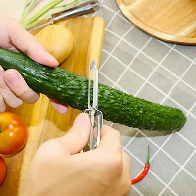Personne en train d'éplucher un concombre avec un éplucheur. Elle tient au-dessus d'une planche à découper sur laquelle et posé des légumes le concombre avec sa main gauche et l'éplucheur avec sa main droite.