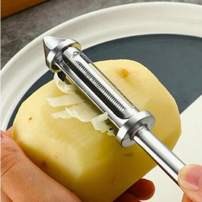 Personne en train de couper en julienne une pomme de terre, elle tient au-dessus d'une assiette la pomme de terre de sa main gauche et l'éplucheur de sa main droite.