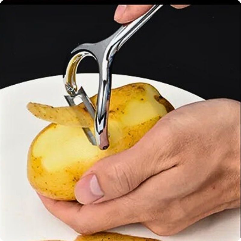 Eplucheur de pomme de terre épluche une pomme de terre