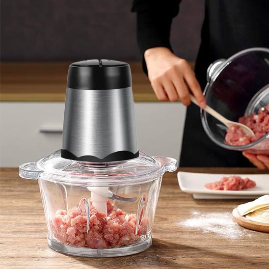 Femme qui utilise le hachoir à viande électrique 