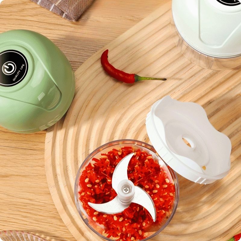 Hachoir électrique vert ouvert avec piment dans réservoir