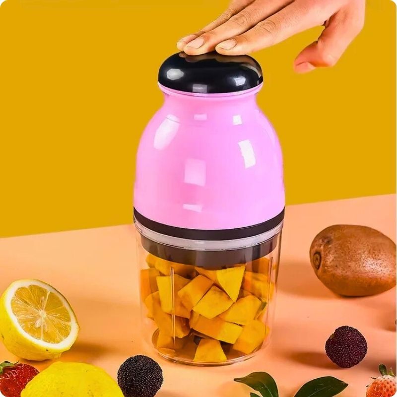 Hachoir électrique sur table avec main posée dessus.