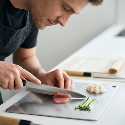 Homme qui coupe sur la planche a decouper en cuisine