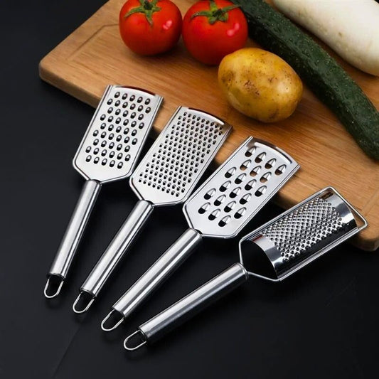 Quatre râpes à fromage sur une planche à découper en bois.