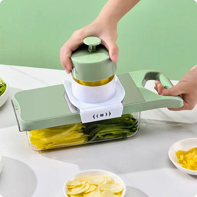 Mandoline cuisine, avec un réservoir, posée sur table.