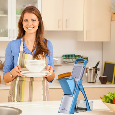Mandoline cuisine posée sur un plan de travail à côté d'une femme qui tient des assiettes.