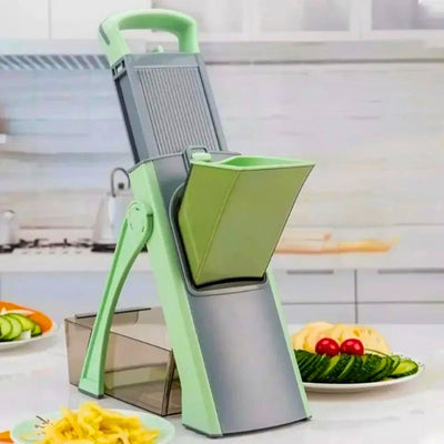 Mandoline cuisine verte posée sur un plan de travail à côté d'assiette de légumes coupés.