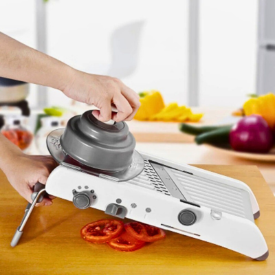 mandoline cuisine coupe une tomate en rondelle.