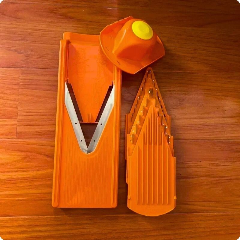 Mandoline japonaise posée sur table avec ustensiles de coupe.