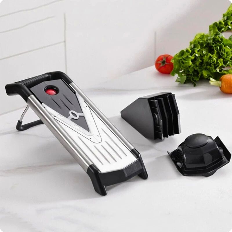 Mandoline japonaise sur table avec ustensiles de coupe à côté.