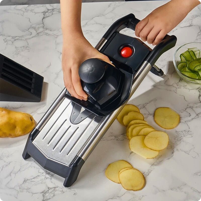 Personne coupant en tranche pomme de terre avec mandoline japonaise