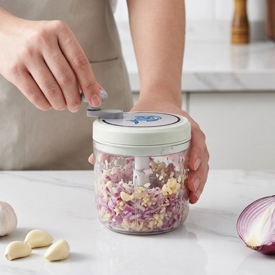 Femme en cuisine qui hache des oignons avec un Mini hachoir manuel