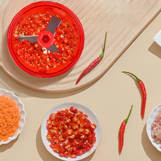 Mini hachoir manuel présenté avec du piment sur une table