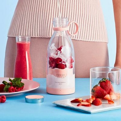 Personne mettant du lait dans un mixeur portable.