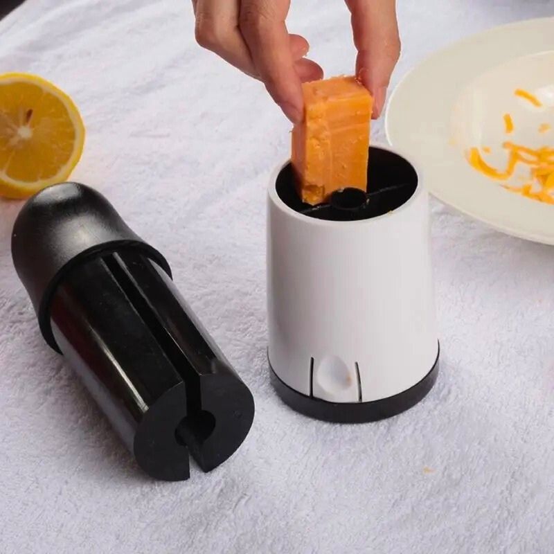Personne qui introduit un morceau de fromage dans une râpe à fromage.