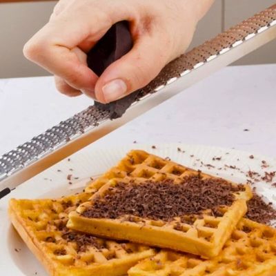 Personne qui râpe du chocolat avec un zesteur.