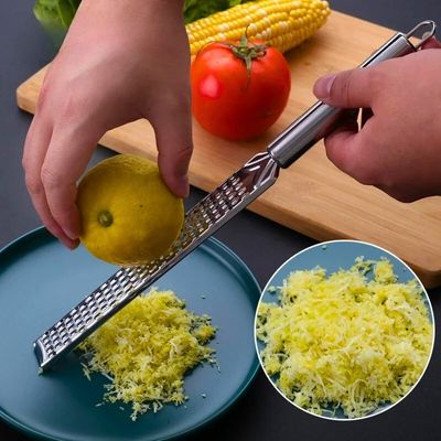 Personne qui râpe un citron avec un zesteur.