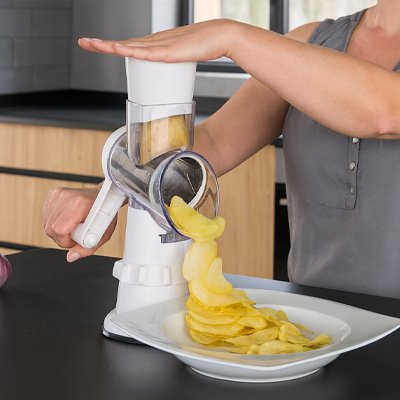 Personne qui tranche des chips rapidement avec la râpe à légumes manuelle chef premium