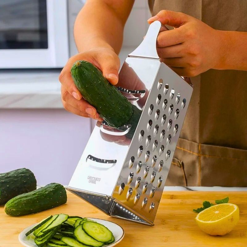 Personne qui tranche un concombre avec une râpe.