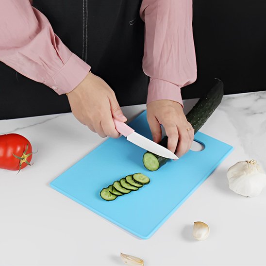 Personne qui utilise la bleu de l'ensemble de planches à découper colorées