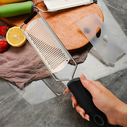 Personne tenant dans sa main une râpe à fromage noire.