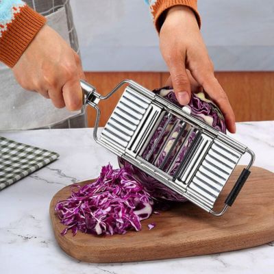 Personne utilisant une râpe à légumes manuelle inox interchangeal'ine pour râper un chou.