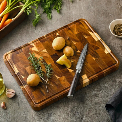 Planche à découper bois posée sur une table avec des légumes et un couteau posés dessus.