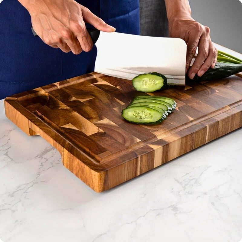planche à découper en bois utilisée pour couper un concombre