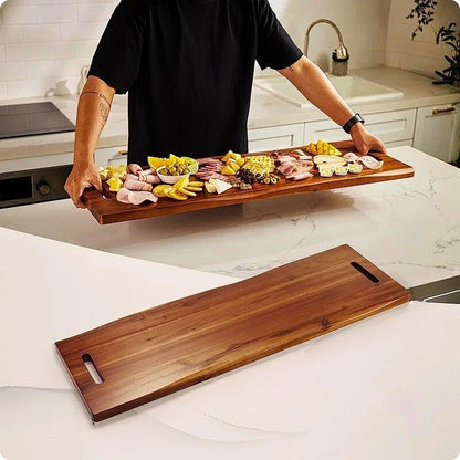Planche à découper en bois XL acacia signature portée avec aliment dessus