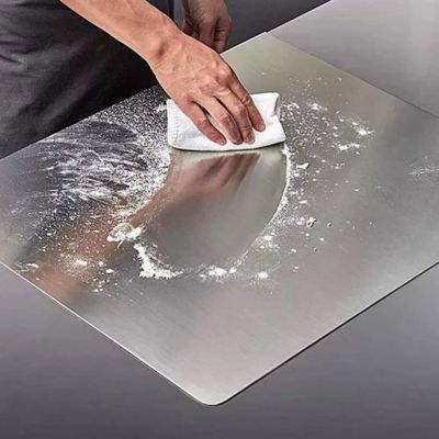 planche à découper en inox en train d'être nettoyée