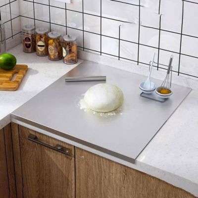 planche à découper en inox spécial'ine posée sur plan de travail avec pâte 