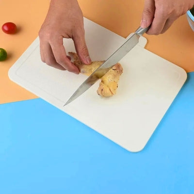 Planche a decouper de couleur blanche utilisée pour découper un poulet.