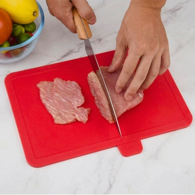 Planche a decouper de couleur rouge utilisée pour découper une viande.