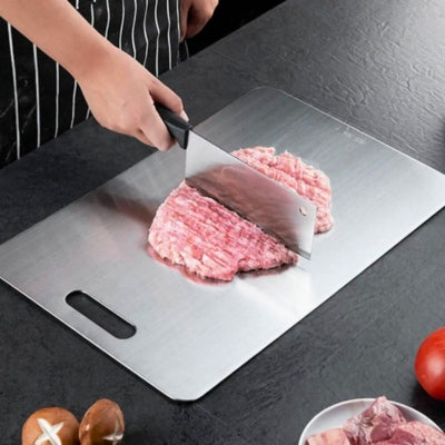 planche à découper inox utilisée par une personne pour hacher de la viande.