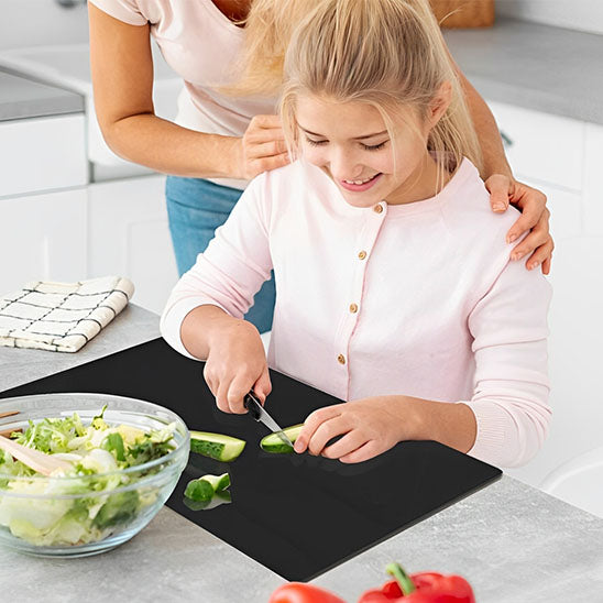 Planche à découper plastique utilisée par une jeune fille.