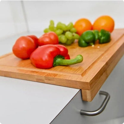 Planche à découper pour plan de travail Moso avec des légumes coupés posés dessus.