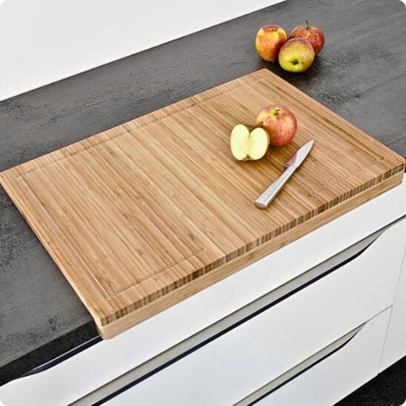 Planche à découper pour plan de travail Moso avec une pomme coupée posée dessus