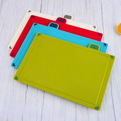planches à découper plastique de couleurs posées sur une table