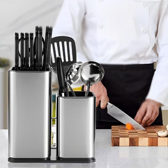Porte couteaux posé sur un plan de travail avec un chef qui travail derrière
