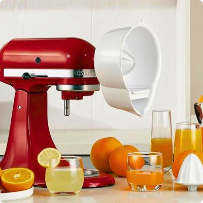 Presse agrume électrique dans la cuisine avec verre de jus d'orange.