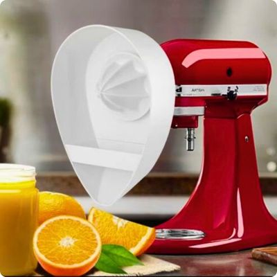 Presse agrume électrique posé sur table avec oranges coupées