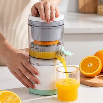 Presse agrume électrique utilisé par une personne qui fait un jus d'orange frais