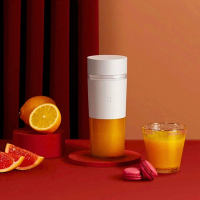 Presse-agrume posé sur une table à côté d'un verre de jus de fruits.