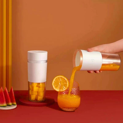 Presse agrume utilisé pour verser dans un verre du jus de fruits, à côté un presse agrume remplit de fruits découpés.