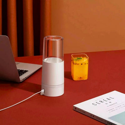 Presse agrume posé sur une table avec un câble de recharge branché.